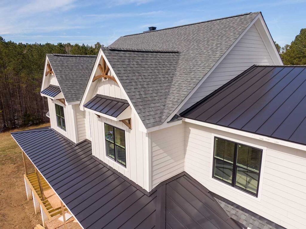Homeowner inspecting roof shingles and clearing leaves from a gutter beside a two-story house